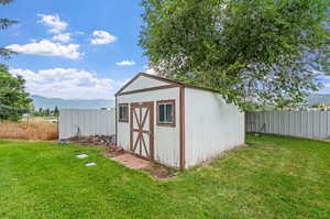 View of outdoor shed with a mountain view and a lawn