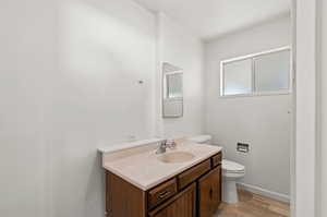 Bathroom with vanity, toilet, and potential shower space. Plumbing is in for shower