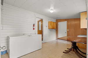 Washroom featuring wood walls, laminate flooring, built in storage