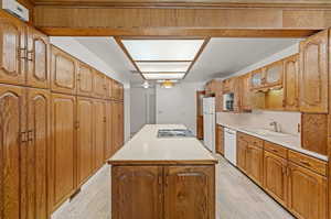 Kitchen with a center island, light hardwood built in cabinets.