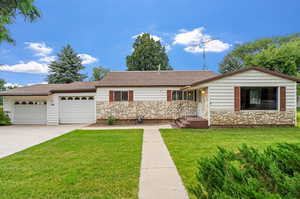 Ranch-style home featuring a garage and a front yard