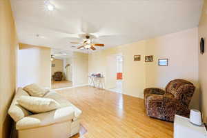 Living room featuring ceiling fan and light hardwood / wood-style flooring