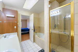 Bathroom with double sink vanity, hardwood / wood-style flooring, and independent shower and bath