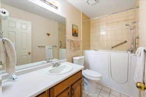 Bathroom featuring toilet, vanity, and tile patterned flooring