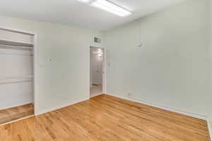 Unfurnished bedroom with a closet and light hardwood / wood-style floors