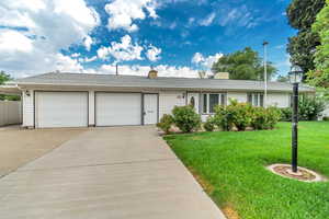 Ranch-style home with a front yard and a garage