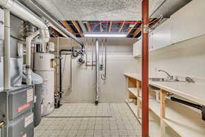 Basement utility room featuring light  patterned flooring and gas water heater & furnace