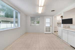 Kitchen featuring light tile patterned flooring and white cabinetry