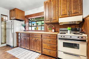 Kitchen featuring gas range and greenhouse window over custom Butcher Block Countertop prep area.