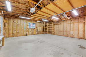 Iside of large garage wlth plenty of  room to park as well as storage and work space.