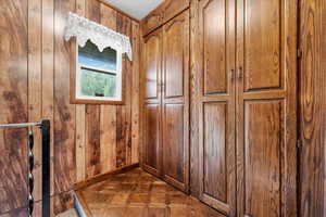 Storage cupboards just off the kitchen with stair rail going down to basement or back door.