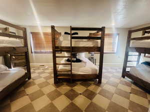 Bedroom featuring baseboards and light floors