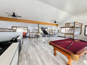Recreation room featuring wood finished floors, baseboards, lofted ceiling, ceiling fan, and pool table