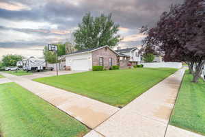 View of front of house with a yard and a garage