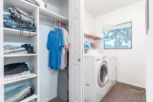 Washroom featuring washing machine and clothes dryer and carpet