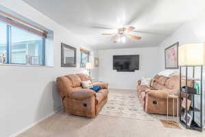 Living room featuring light carpet and ceiling fan