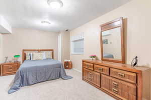 Carpeted bedroom featuring a textured ceiling