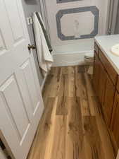 Full bathroom featuring hardwood / wood-style flooring, vanity, toilet, and bathing tub / shower combination