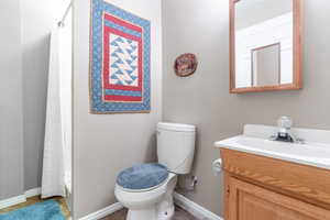 Bathroom with toilet, tile patterned floors, and vanity