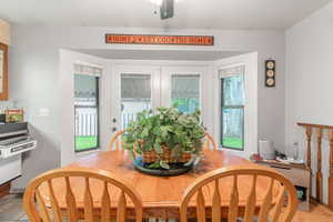 Dining room featuring ceiling fan, light tile patterned flooring, french doors, and a healthy amount of sunlight