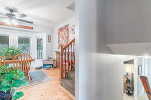 Corridor with lofted ceiling and light hardwood / wood-style floors