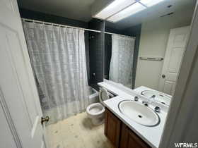 Full bathroom featuring shower / bathtub combination with curtain, tile patterned floors, vanity, and toilet