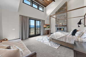 Bedroom featuring light carpet, high vaulted ceiling, wood ceiling, and multiple windows