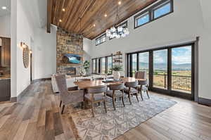 Dining space with wood-type flooring, wooden ceiling, and high vaulted ceiling