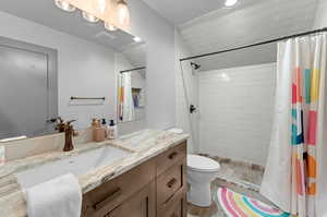 Bathroom with wood-type flooring, walk in shower, vanity, and toilet