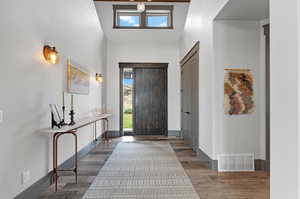 Foyer entrance featuring a high ceiling, plenty of natural light, and hardwood / wood-style floors