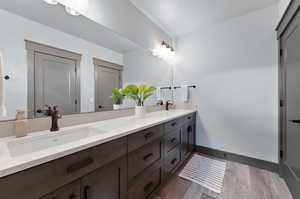 Bathroom featuring hardwood / wood-style flooring and dual vanity