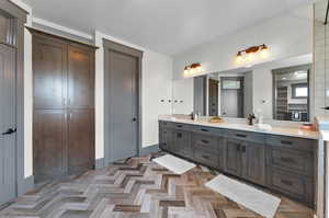 Bathroom featuring dual vanity and parquet flooring