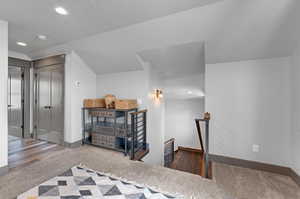 Bedroom with vaulted ceiling, dark carpet, and a closet