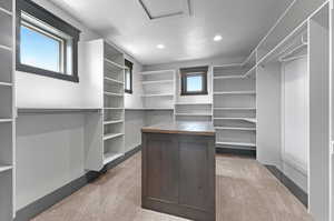 Walk in closet with light colored carpet