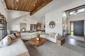 Living room featuring hardwood / wood-style floors, high vaulted ceiling, beam ceiling, and wood ceiling