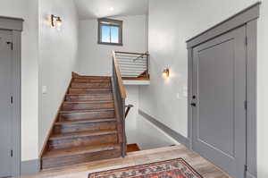 Stairway featuring lofted ceiling and hardwood / wood-style flooring