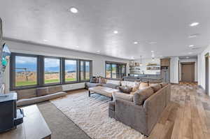 Living room with light wood-type flooring and a textured ceiling