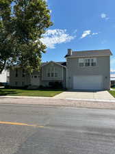 View of front of house with a garage and a front lawn