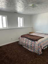 Carpeted bedroom featuring a textured ceiling