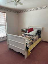 Carpeted bedroom with ceiling fan and a textured ceiling