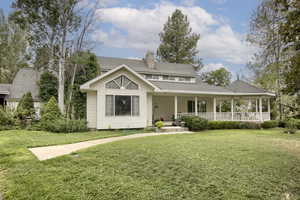 View of front of house featuring a front lawn and a porch