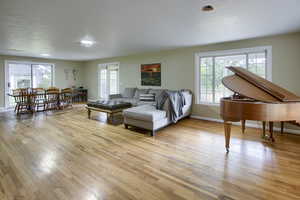 Living room with french doors and light hardwood / wood-style flooring