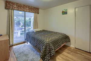 Bedroom featuring light wood-type flooring, access to outside, and a closet