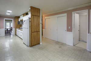 Kitchen featuring light tile patterned floors, gas cooktop, and white fridge