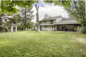 Rear view of property featuring a lawn and a patio area