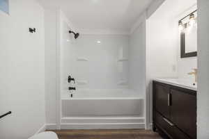 Primary Full bathroom with bathing tub / shower combination, vanity, and hardwood / wood-style floors