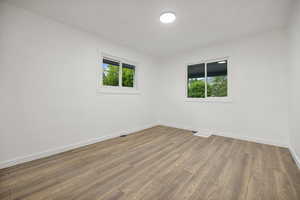 Bedroom 1 featuring wood-type flooring and a wealth of natural light