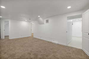 Basement with light colored carpet