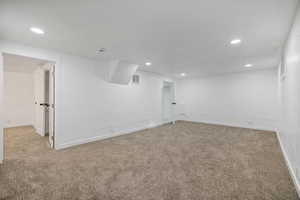 Basement featuring light colored carpet