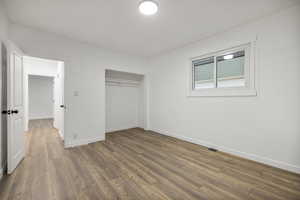 Bedroom 1 featuring hardwood / wood-style flooring and a closet